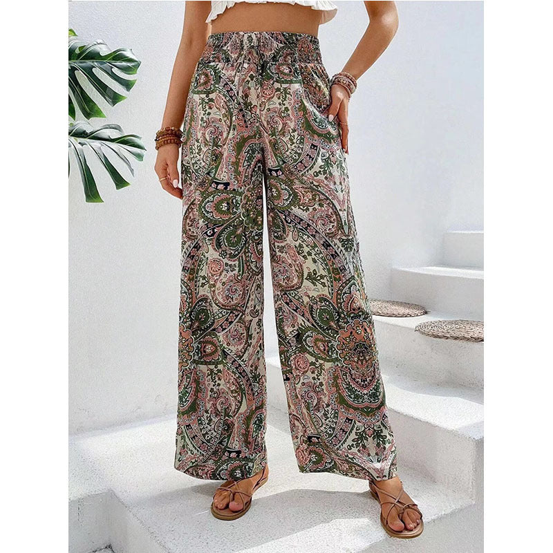 Person wearing patterned wide-leg pants on a white staircase.