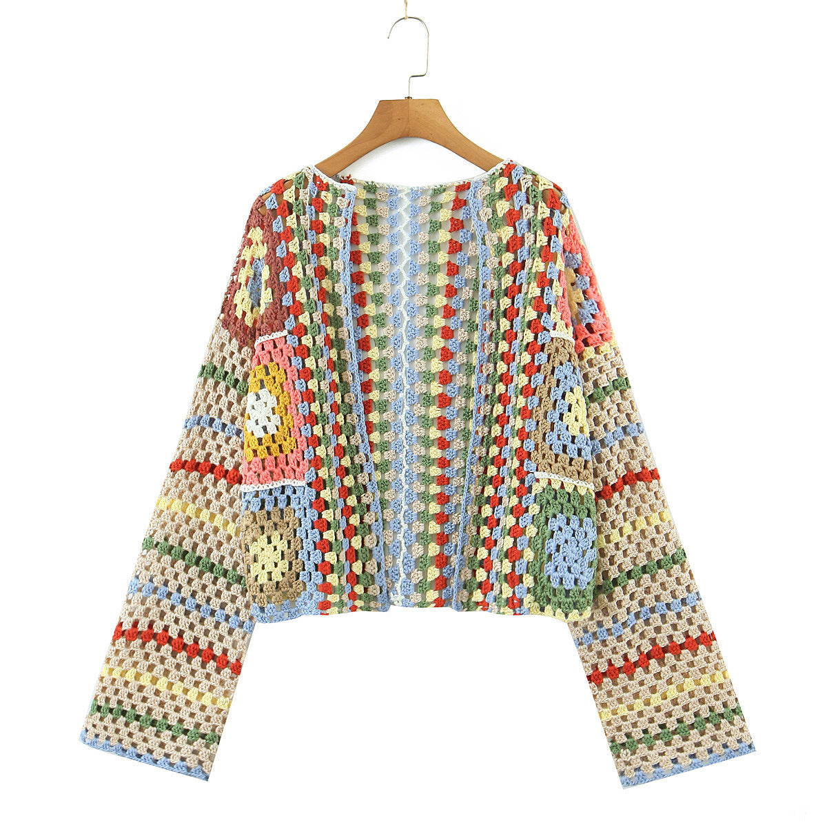 Colorful crocheted cardigan on a wooden hanger against a white background
