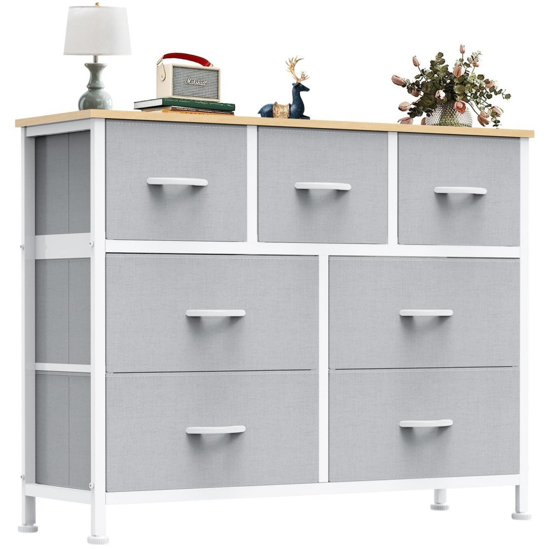 Gray dresser with multiple drawers and a wooden top.