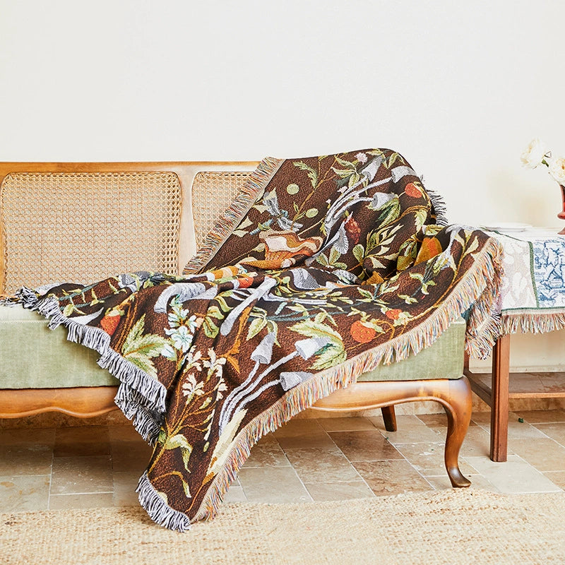 Decorative floral-patterned throw blanket draped over a wicker chair.