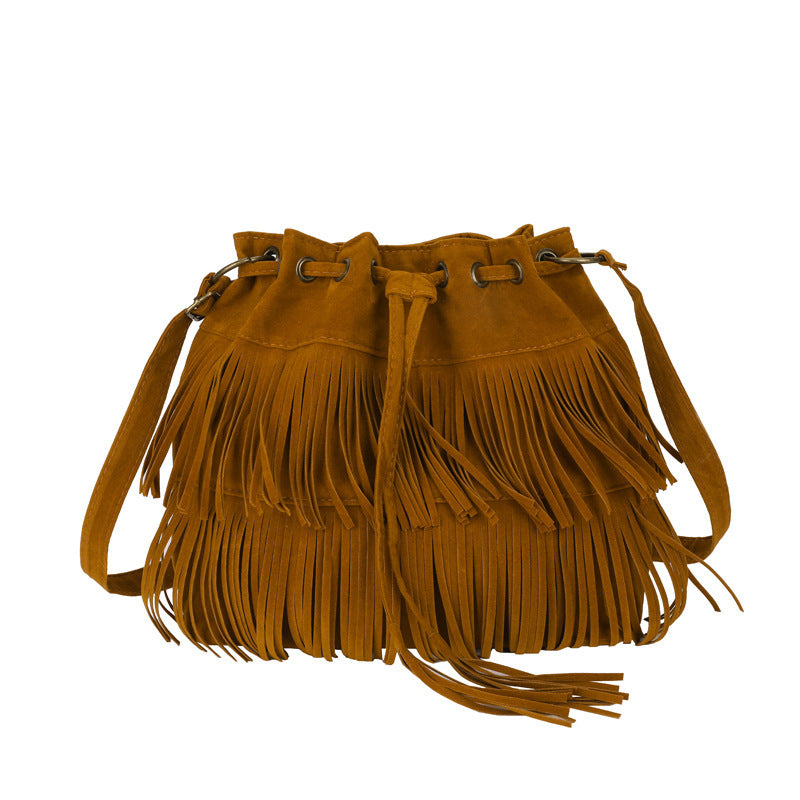 Brown suede handbag with fringes on a white background