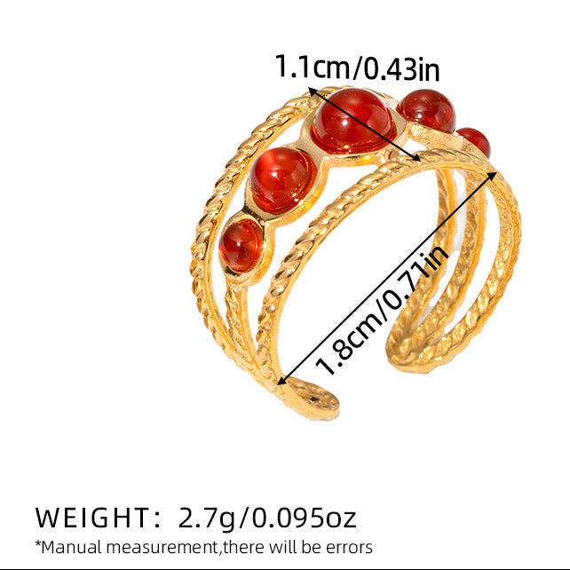 Gold ring with red stones and measurements on a white background