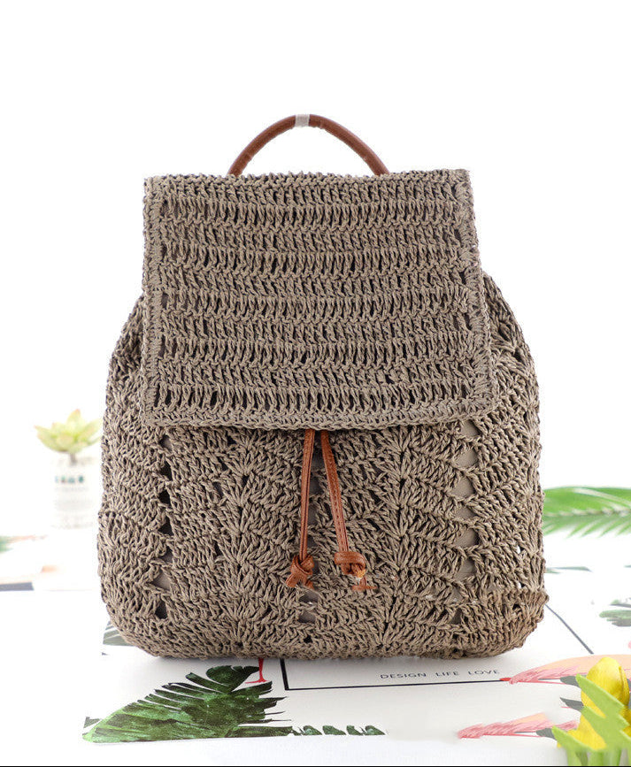 Brown crochet backpack on a white background with green leaves and flowers.