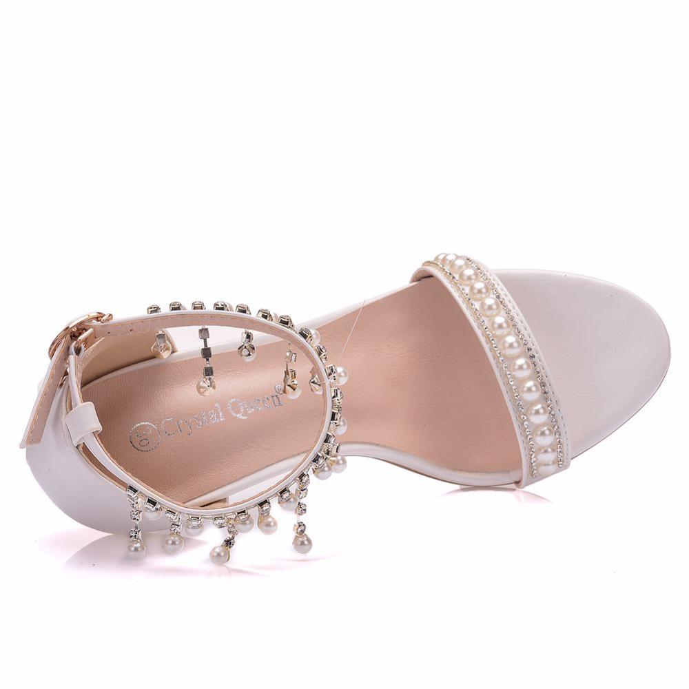 White sandal with pearl and crystal embellishments on a white background