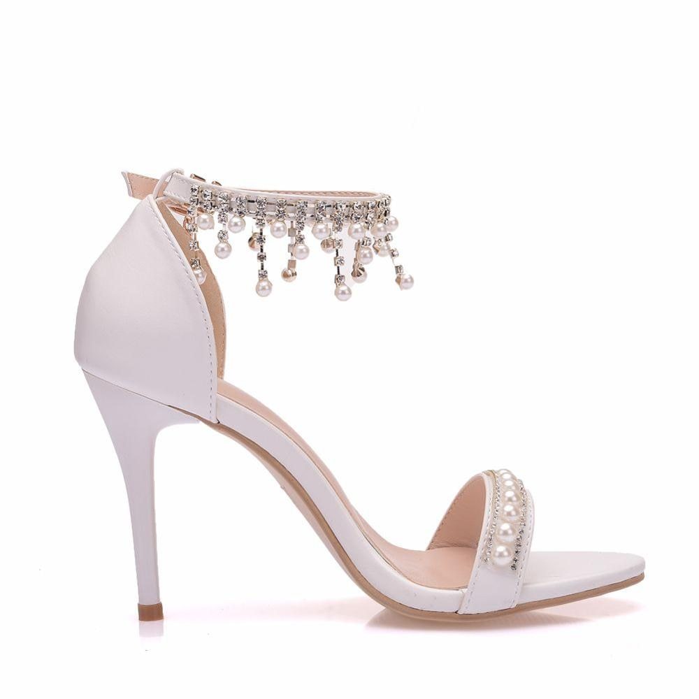 White high-heeled sandal with pearl embellishments on a white background