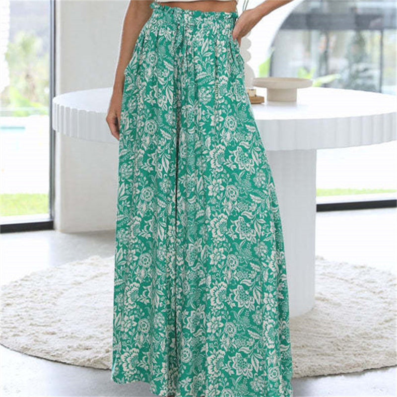 Green floral pants worn by a person in a bright room with large windows.