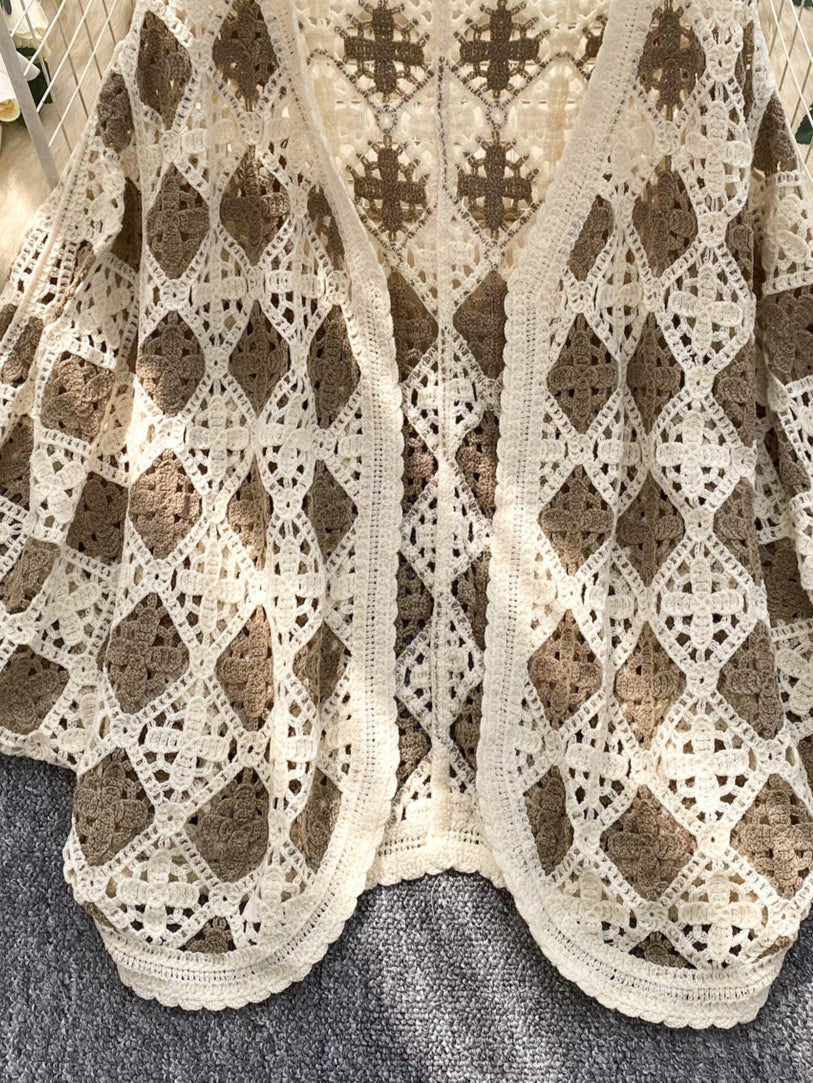 Crocheted vest with diamond pattern on a hanger against a floral background