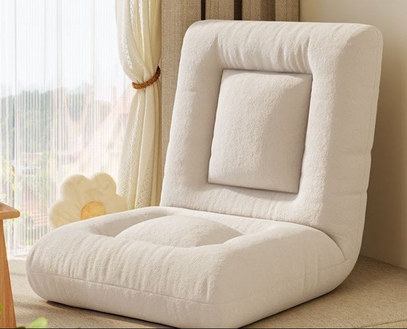 White floor chair in a room with curtains and a lamp.