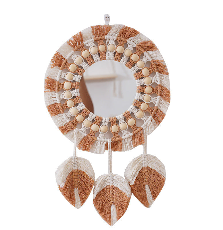 Decorative wall mirror with macrame design and wooden beads on a white background