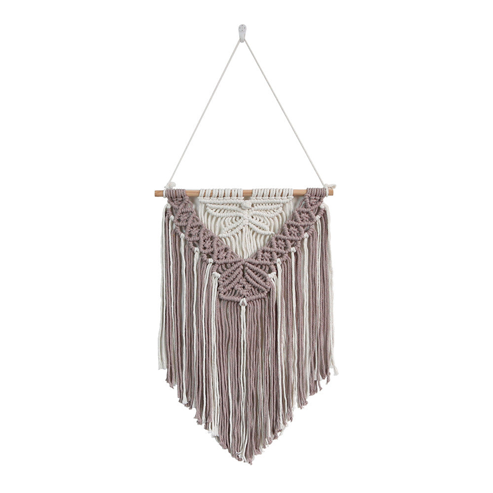 Macrame wall hanging with fringe design on a white background