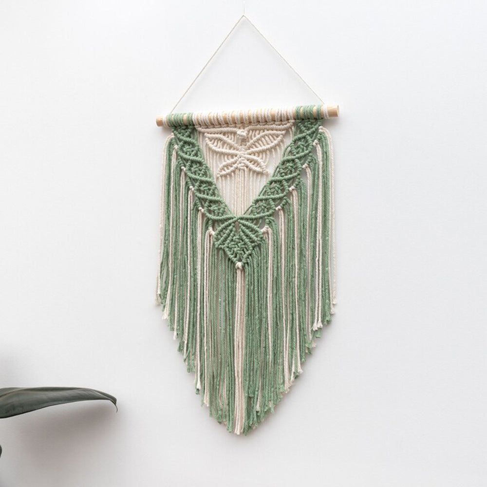 Green and white macrame wall hanging on a white background