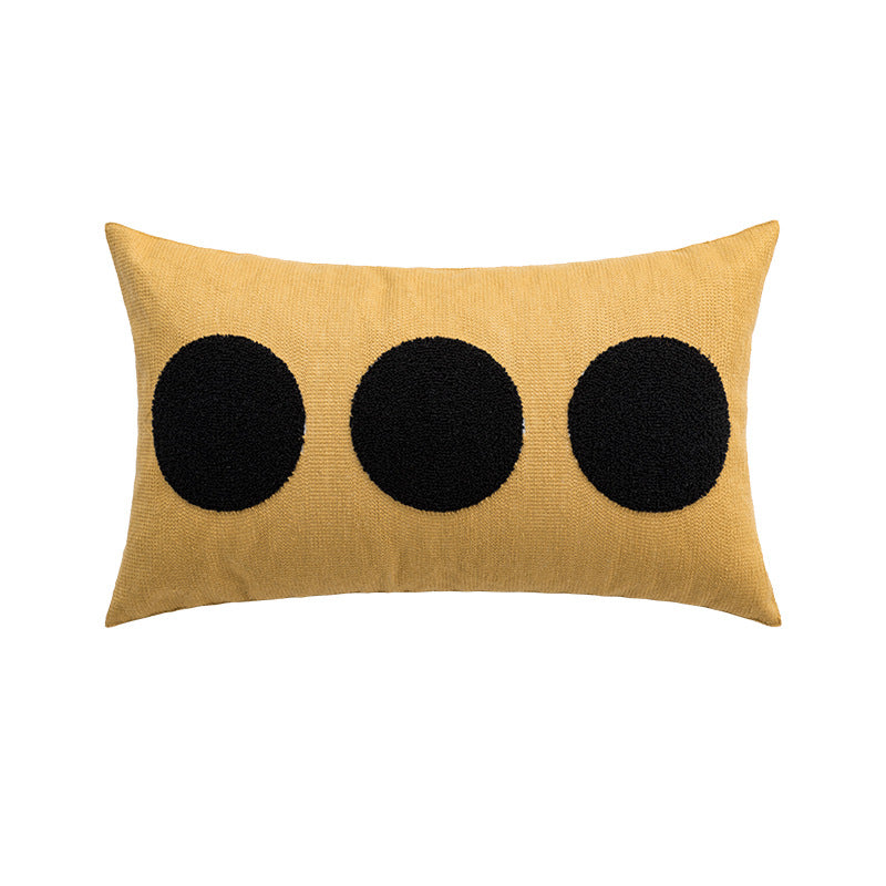 Yellow pillow with three black circular patterns on a white background
