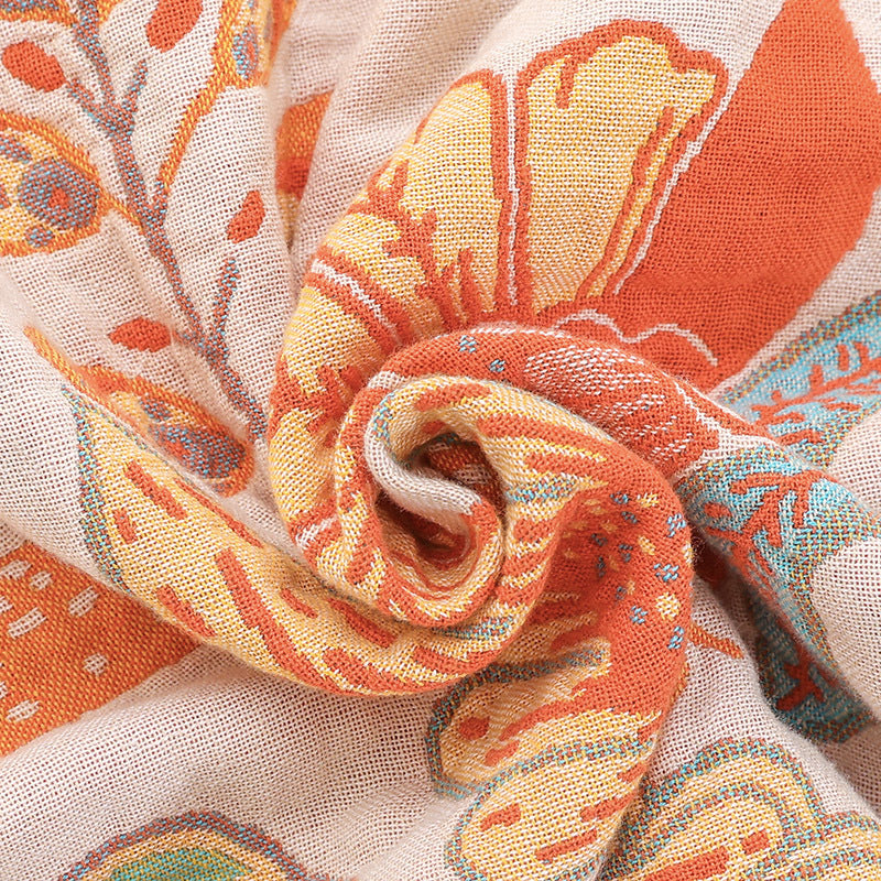 Close-up of a colorful fabric with intricate patterns in orange, yellow, and blue.