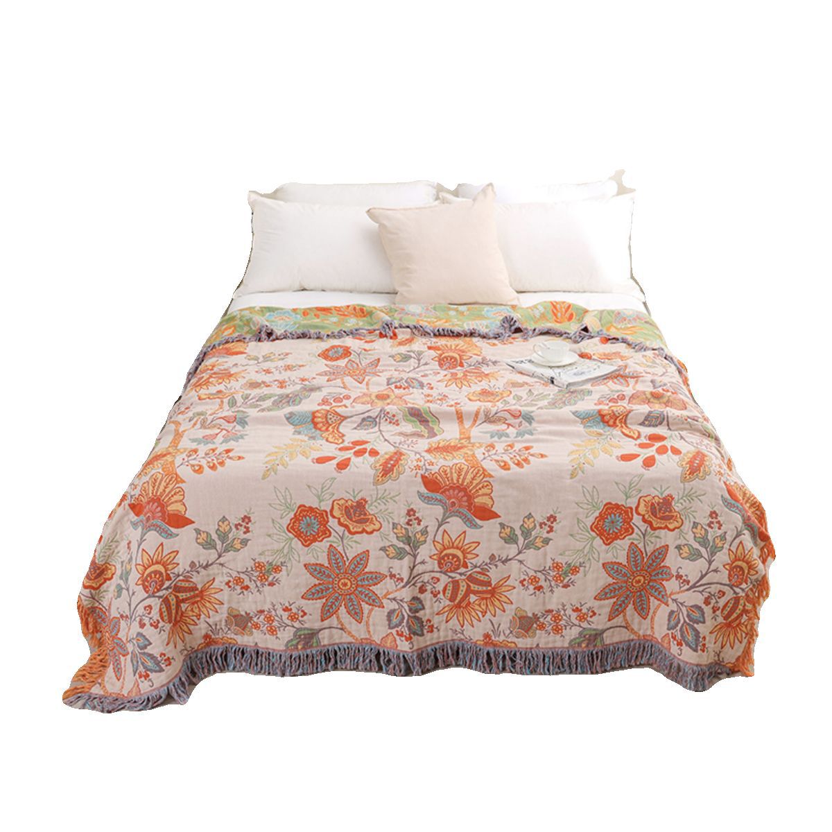 Floral patterned quilt on a bed with white pillows against a white background