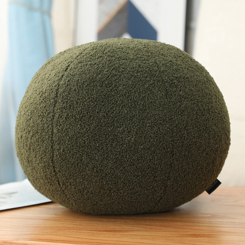 Green textured ball on a wooden surface with a blurred background