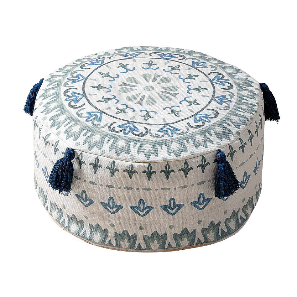 Decorative ottoman with intricate patterns and tassels on a white background