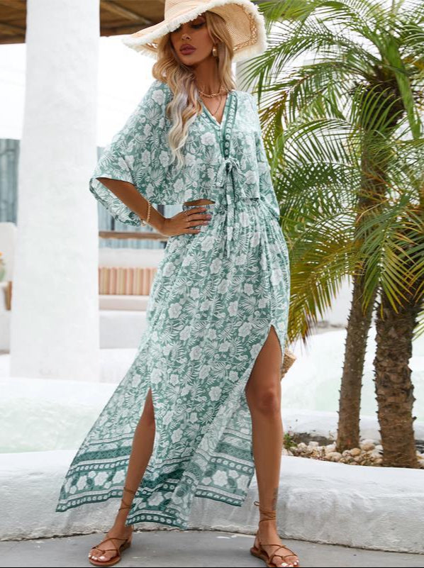 Woman wearing a green floral dress with a palm tree in the background