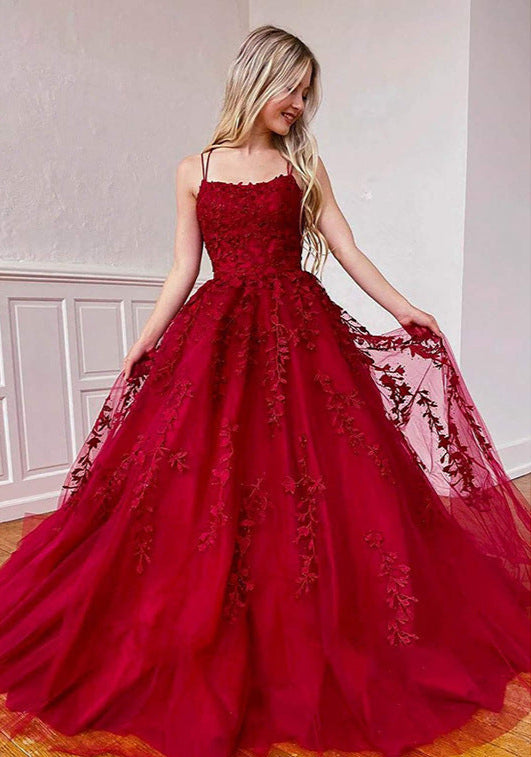 Red lace evening gown worn by a model indoors.