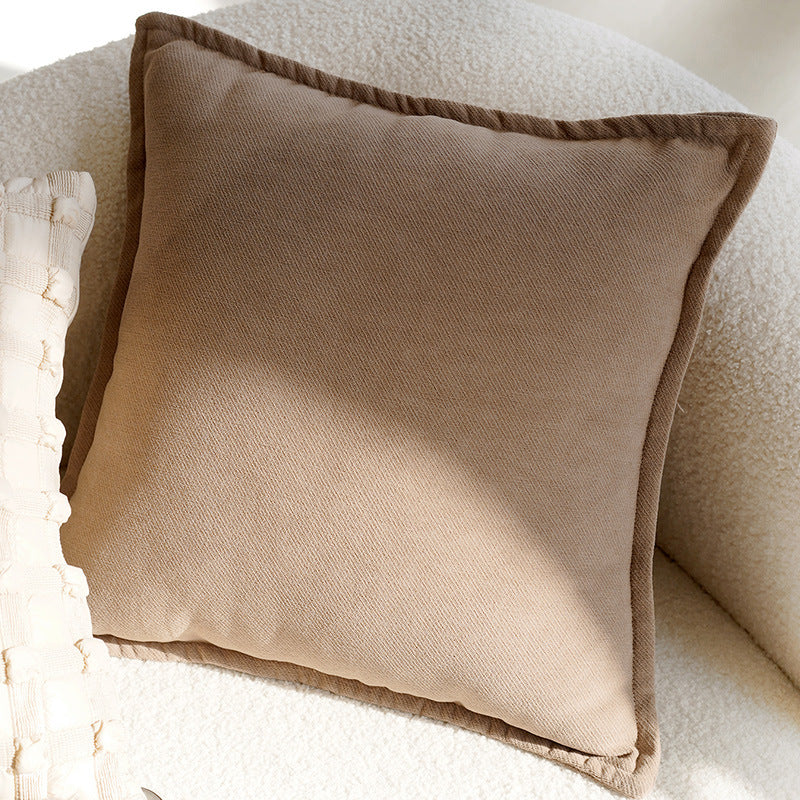 Brown pillow on a textured beige surface