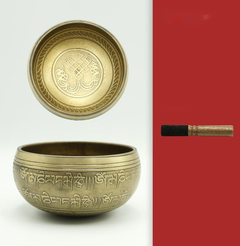 Bronze singing bowl with decorative patterns on a white background