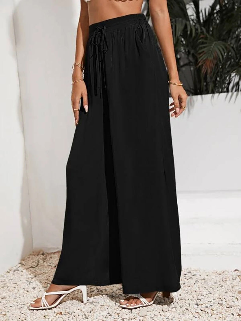 Person wearing black wide-leg pants with a white background