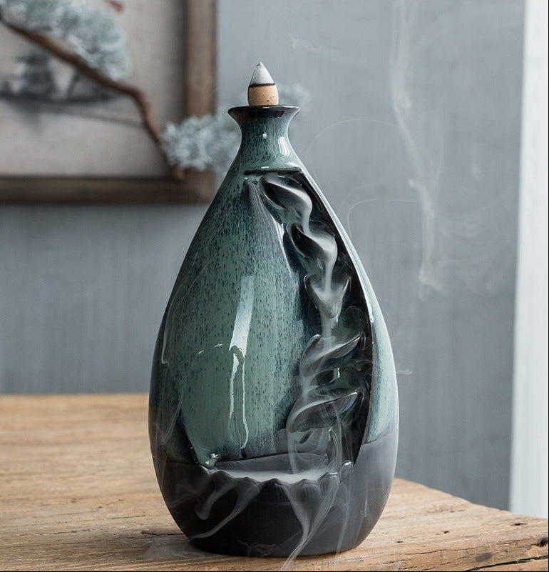 Ceramic incense burner with decorative design on a wooden surface