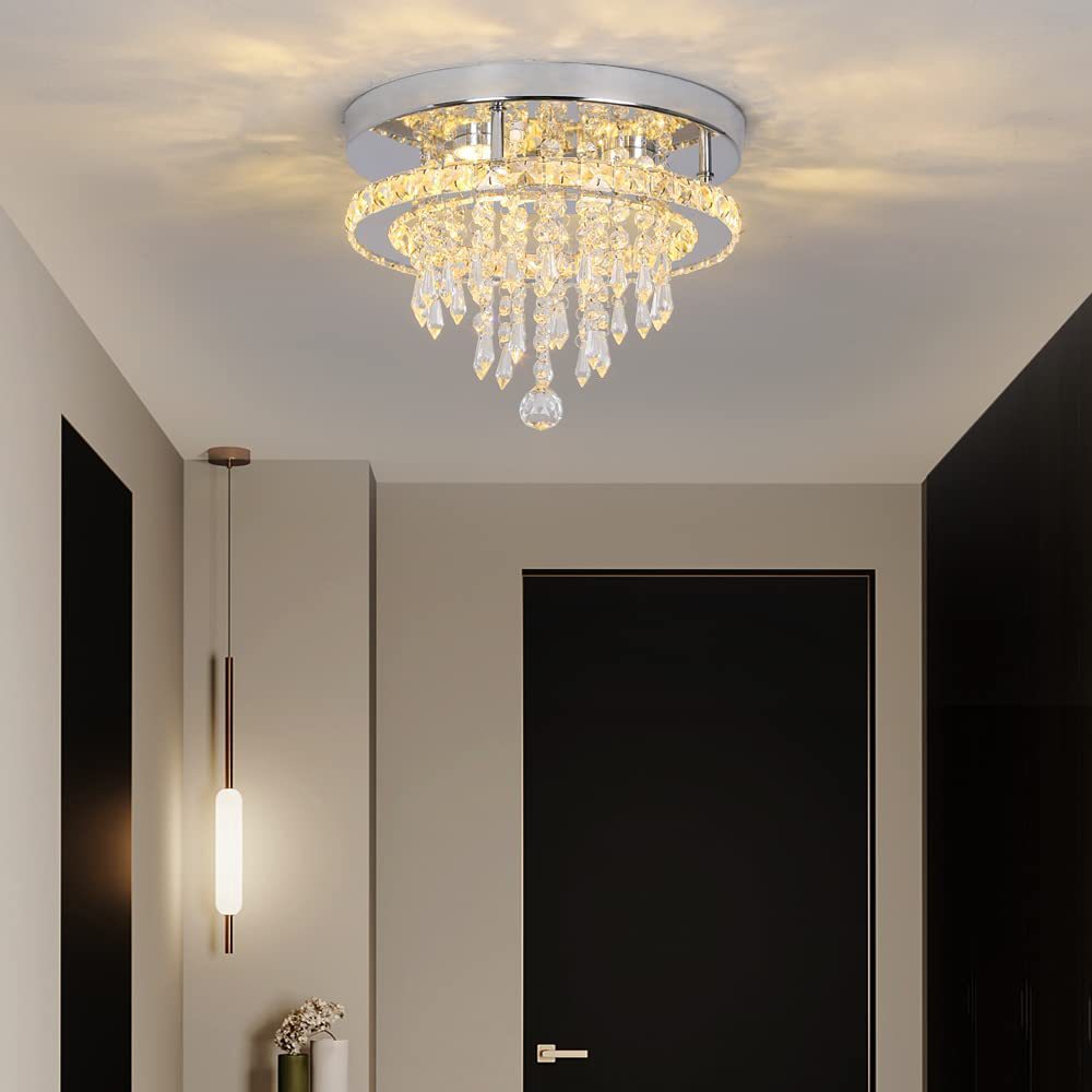 Chandelier hanging from a ceiling in a room with a door and wall sconce.