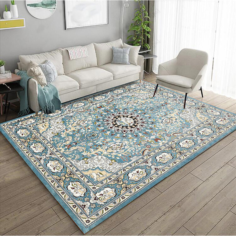 Decorative blue rug with intricate patterns in a living room setting.