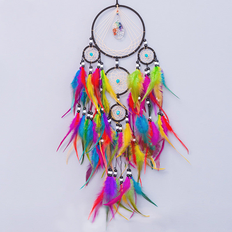 Colorful dreamcatcher with feathers on a light gray background