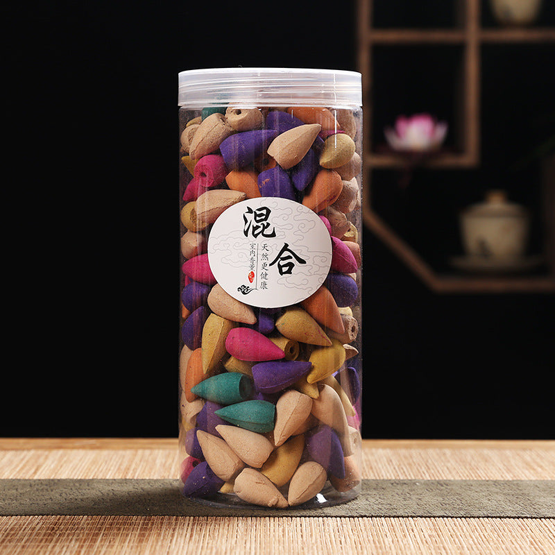 Colorful incense cones in a cylindrical container with a label on a wooden surface.