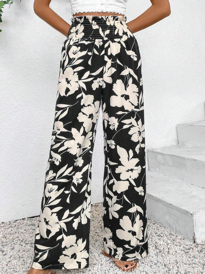 Floral patterned pants worn by a person on a white background