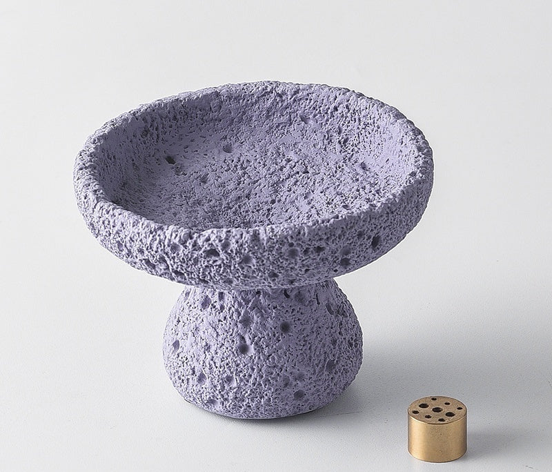 Concrete bowl with a small brass component on a light gray background