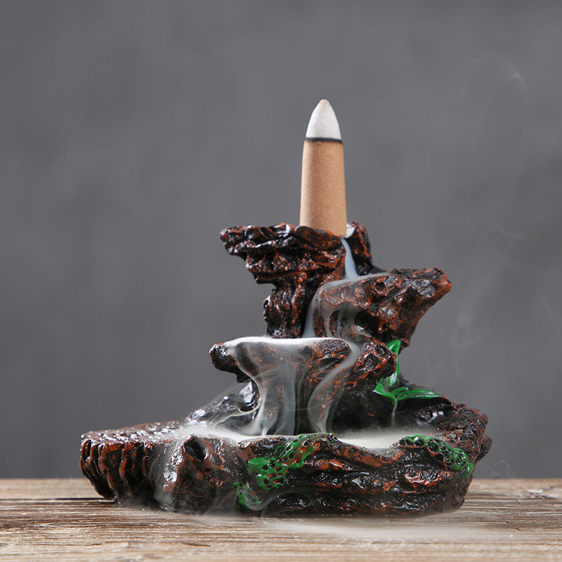 Decorative incense burner with a natural rock design on a wooden surface.