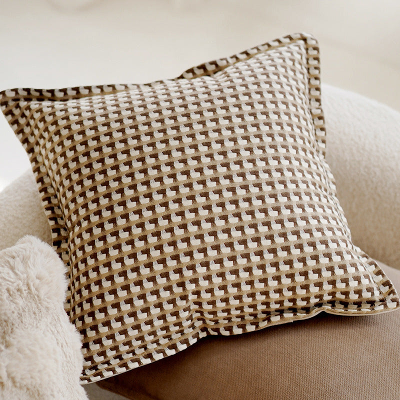 Decorative pillow with a geometric pattern on a beige sofa