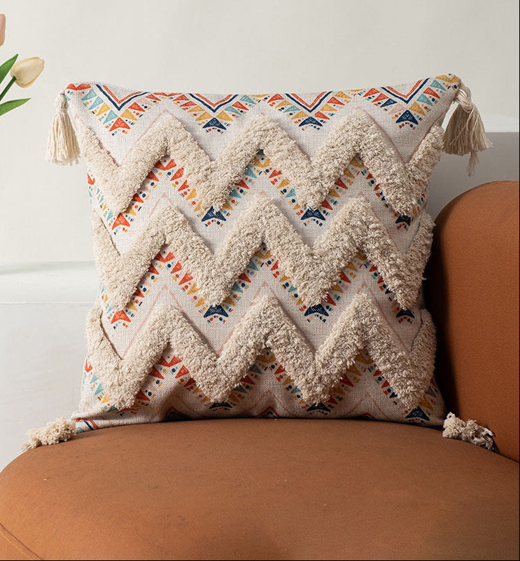 Decorative pillow with chevron pattern and tassels on a brown couch