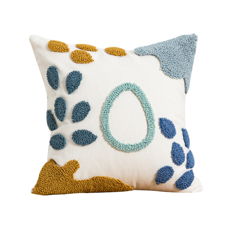 Decorative pillow with geometric patterns in blue, yellow, and white on a white background