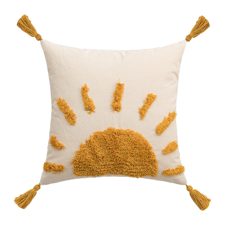 Decorative pillow with sun design and tassels on a white background