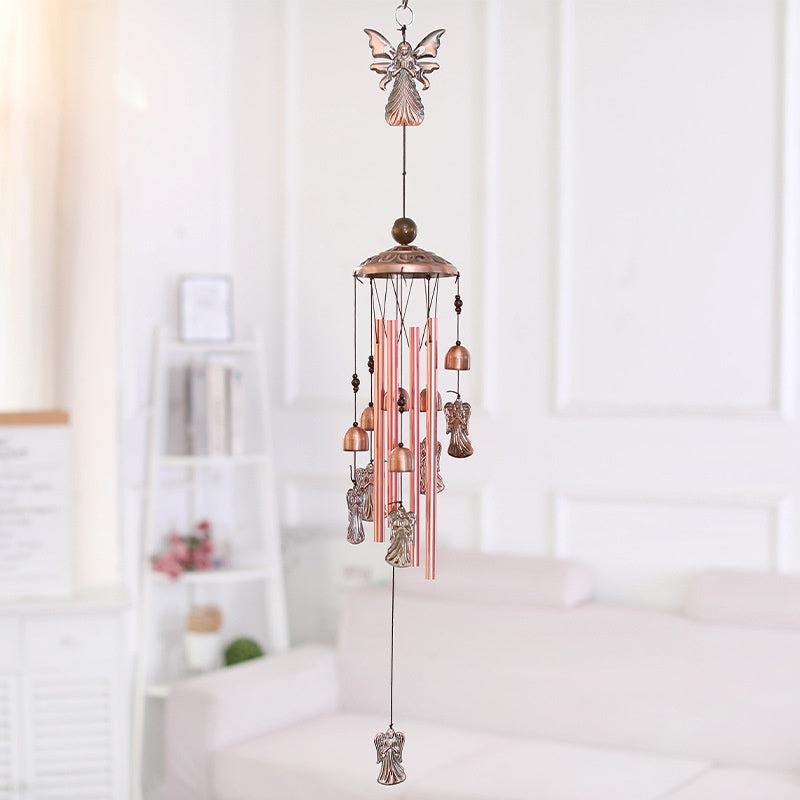Decorative wind chime with angelic design hanging in a room.