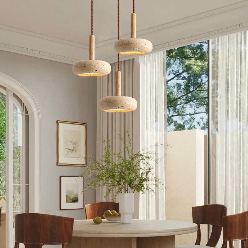 Dining room with wooden pendant lights, table, chairs, and decor.