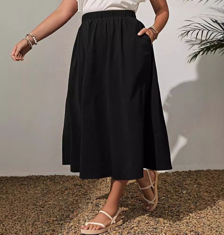Person wearing a black skirt with a white wall and plant in the background