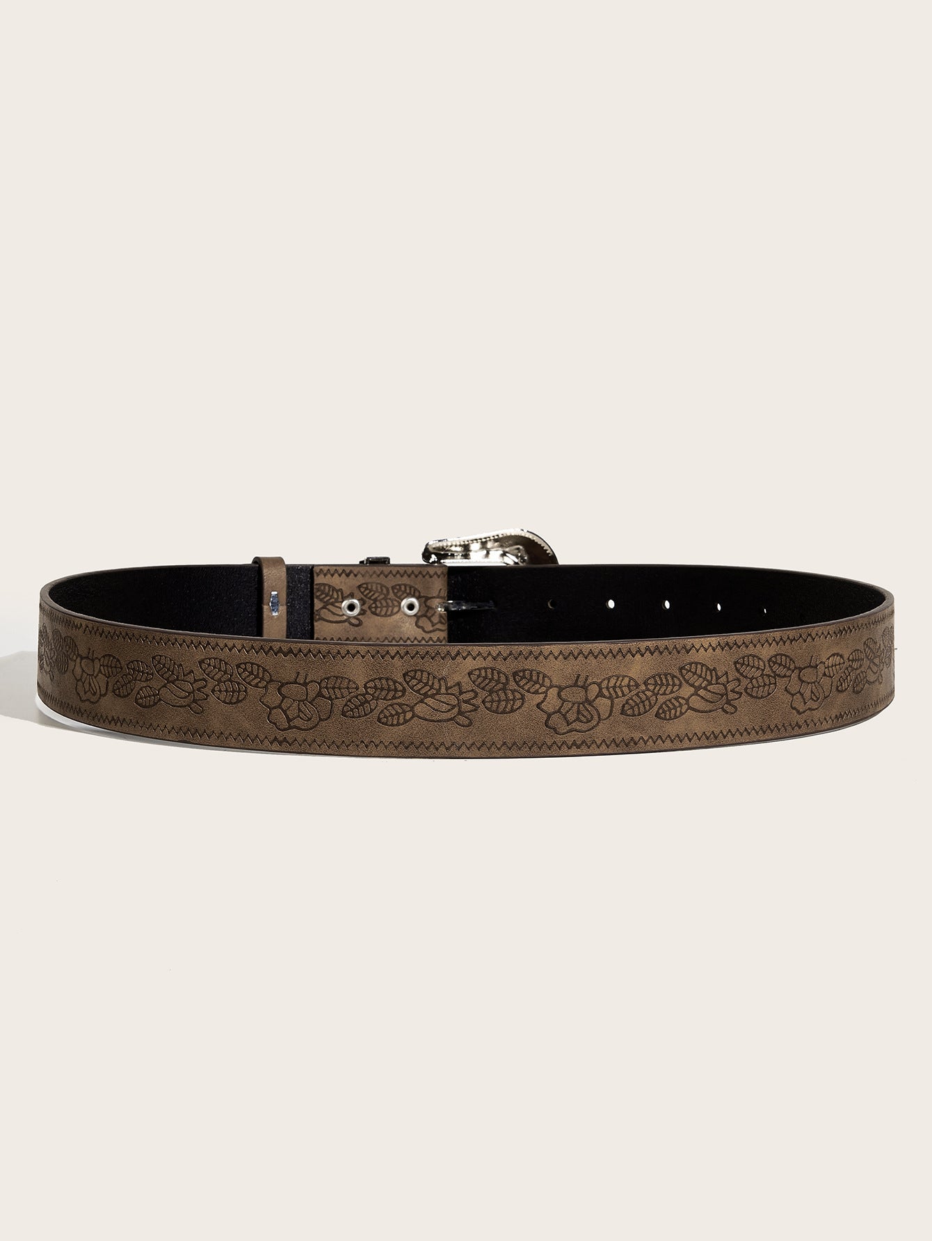 Brown leather belt with floral embossing on a beige background