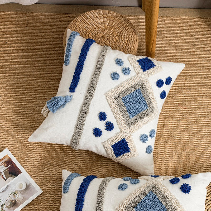 Decorative pillow with blue and gray patterns on a textured surface