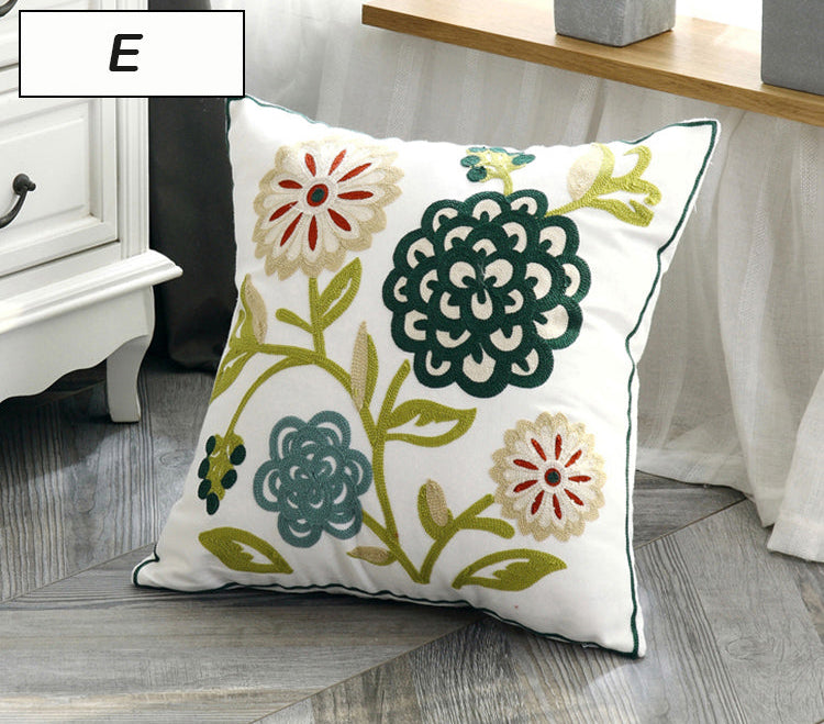 Decorative pillow with floral patterns on a wooden floor.