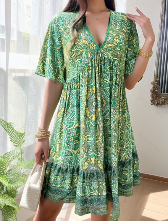 Woman wearing a green patterned dress holding a white handbag indoors.