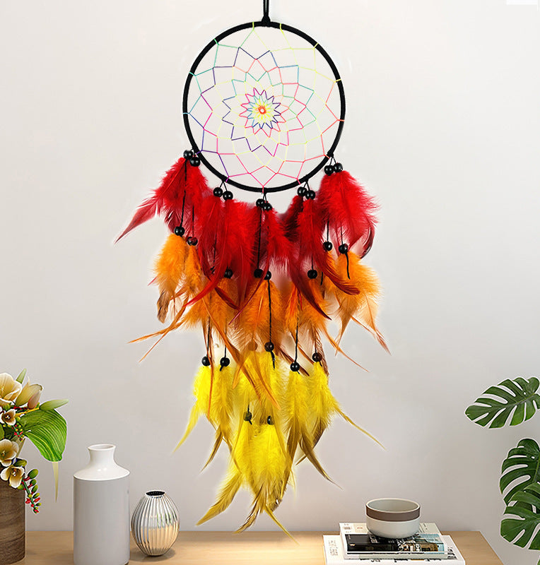 Colorful dreamcatcher with feathers on a light gray wall with decorative items.
