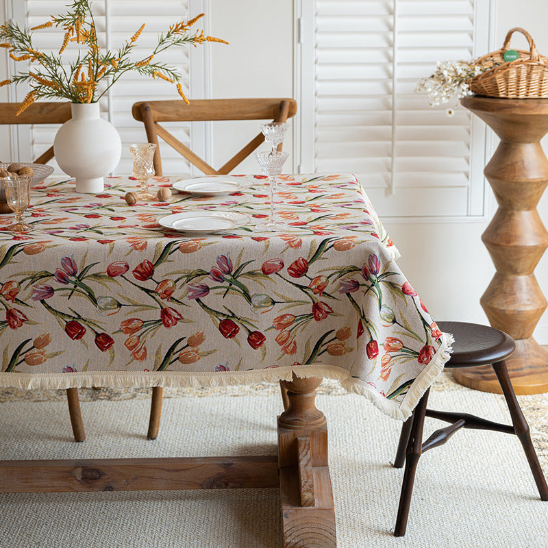 Floral tablecloth on a wooden dining table with a rustic setting.