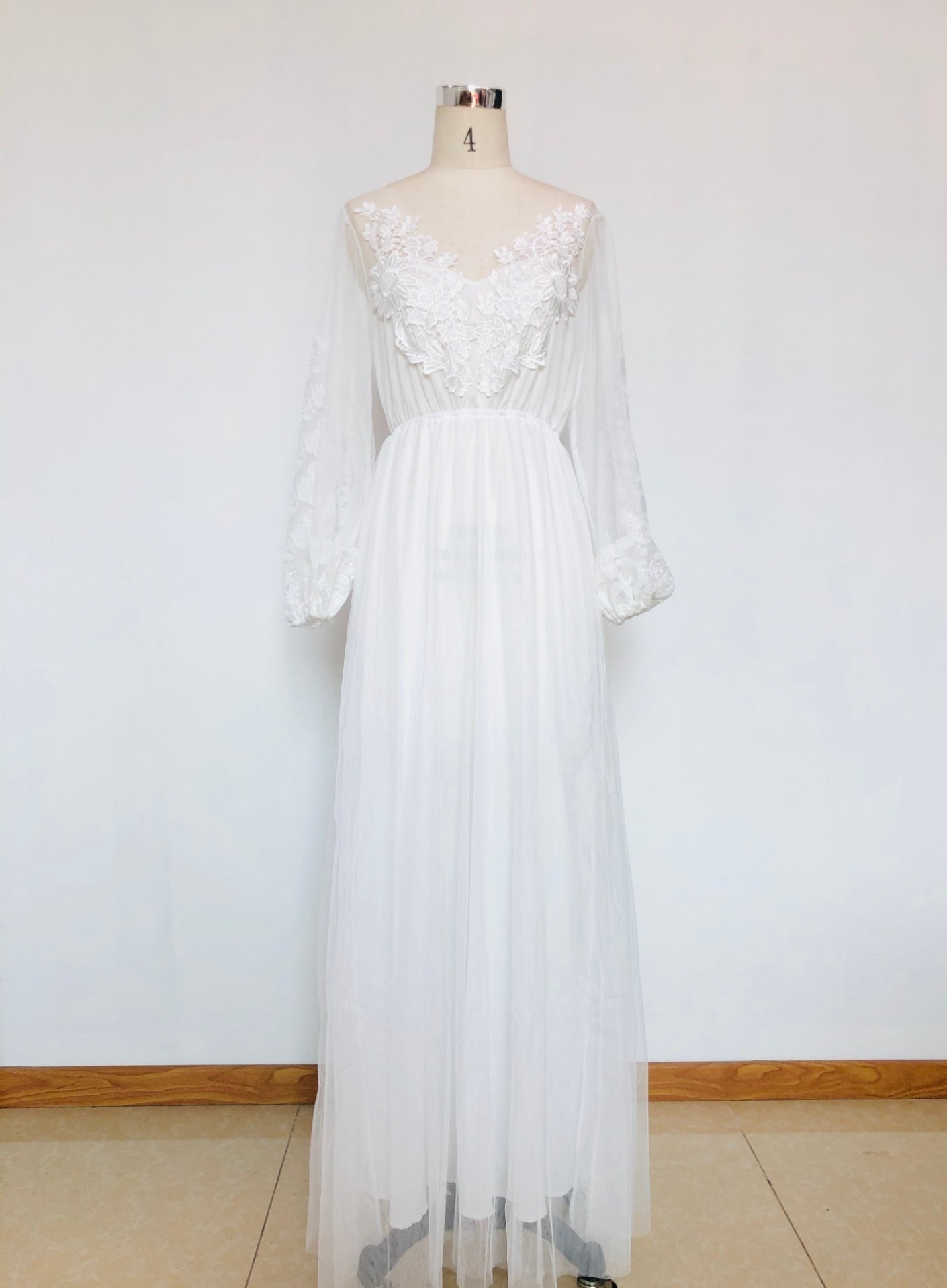 White lace dress on a mannequin against a white background