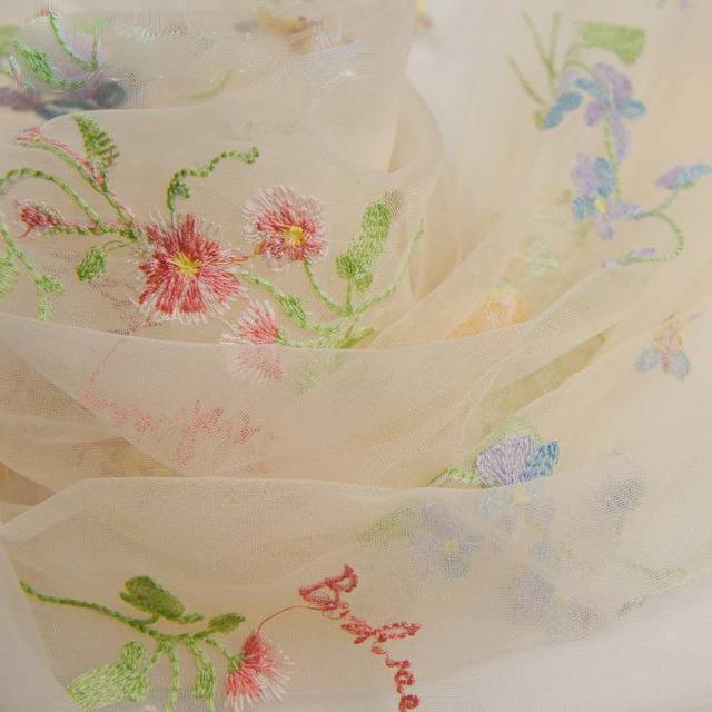 Embroidered fabric with floral patterns on a beige background