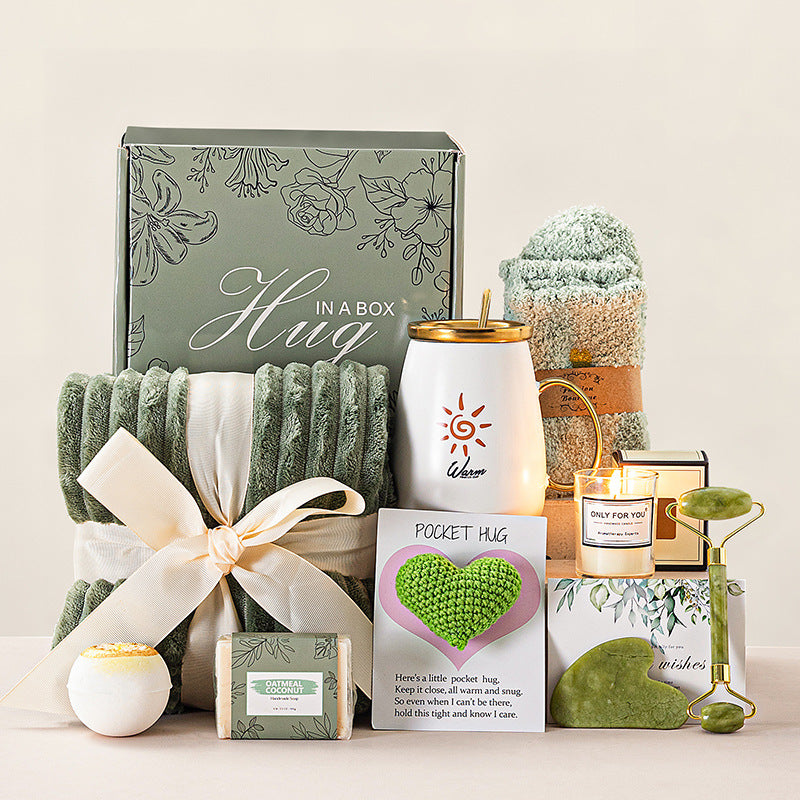 Gift set with a blanket, candles, and other items on a light background