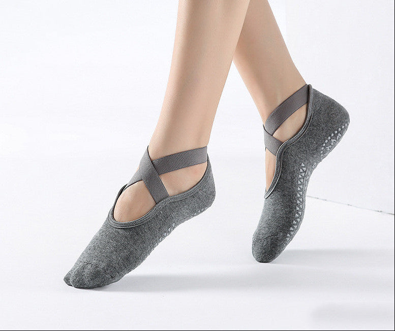 Gray ballet-style socks with straps worn by a person on a white background